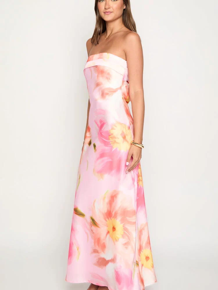 Side view of a pink floral print strapless maxi dress with a flowy silhouette