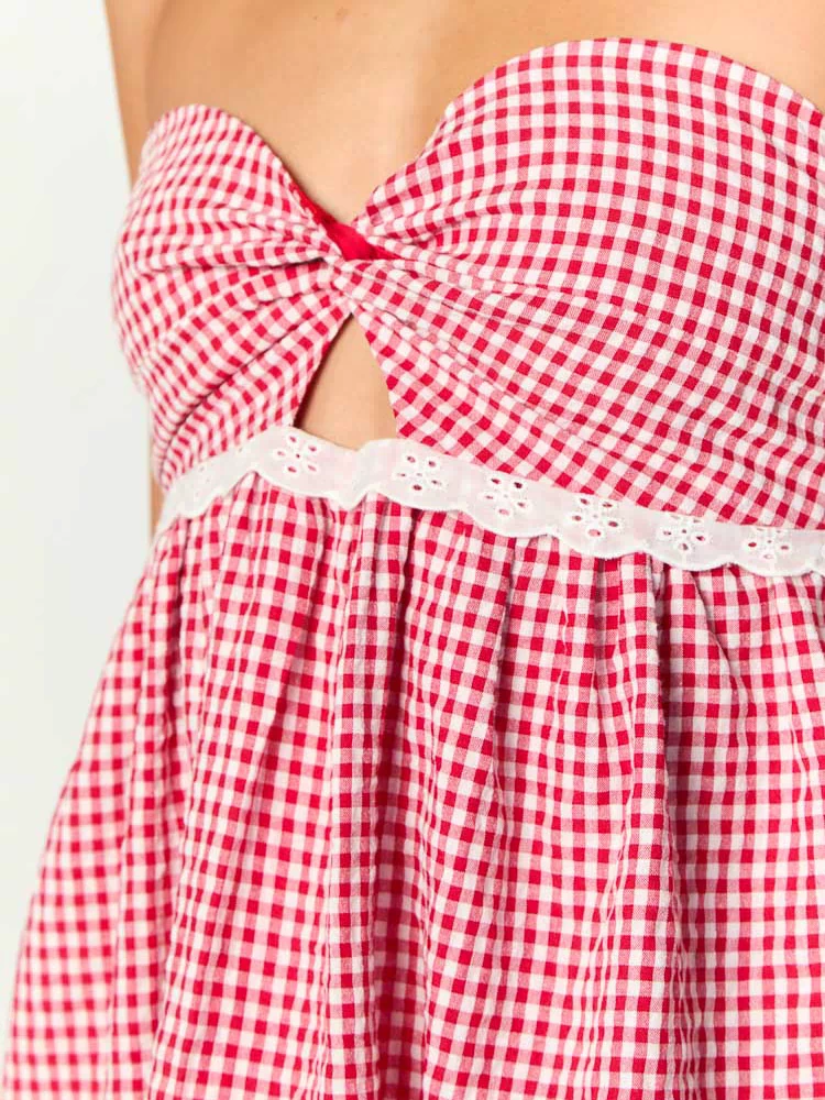 Close-up of the red gingham dress showing the twisted knot bust, underbust cutout, and white eyelet lace trim
