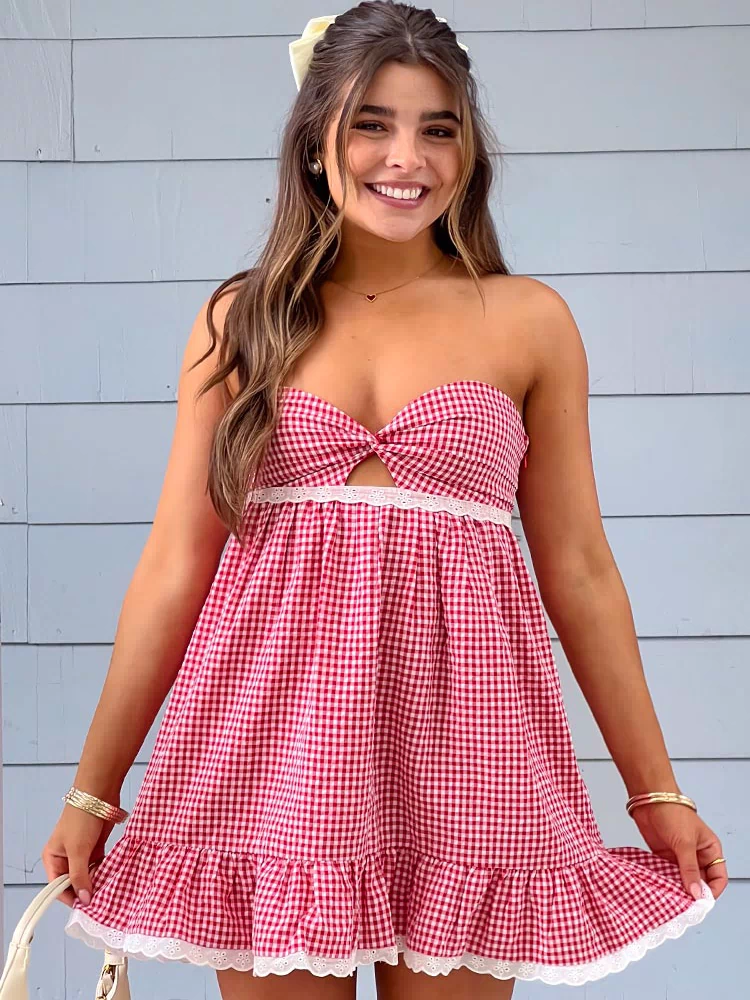 Front view of a red gingham strapless mini dress with a twisted knot bodice and white lace trims