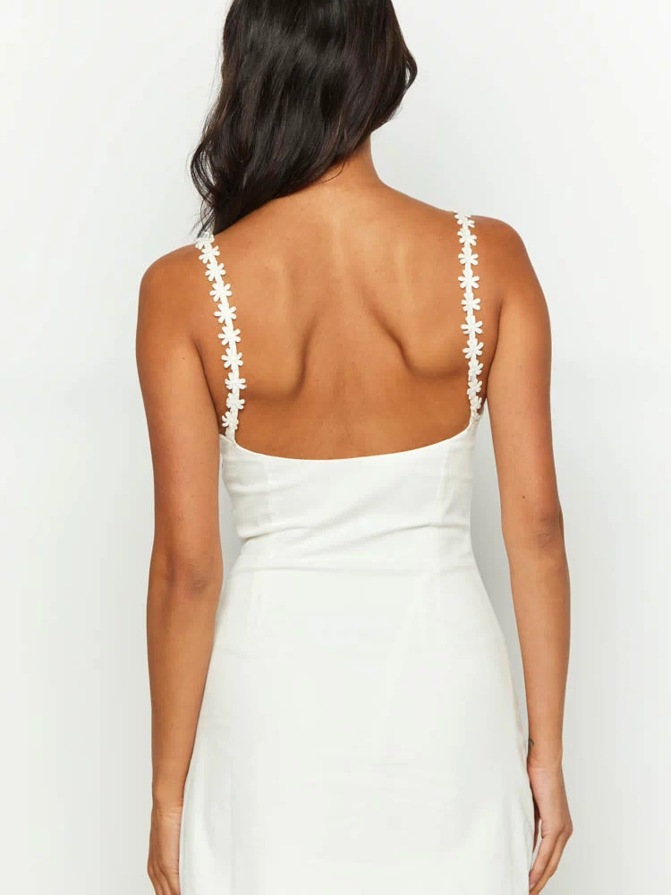 Rear view of a white mini dress with a low scoop back and daisy-chain shoulder straps