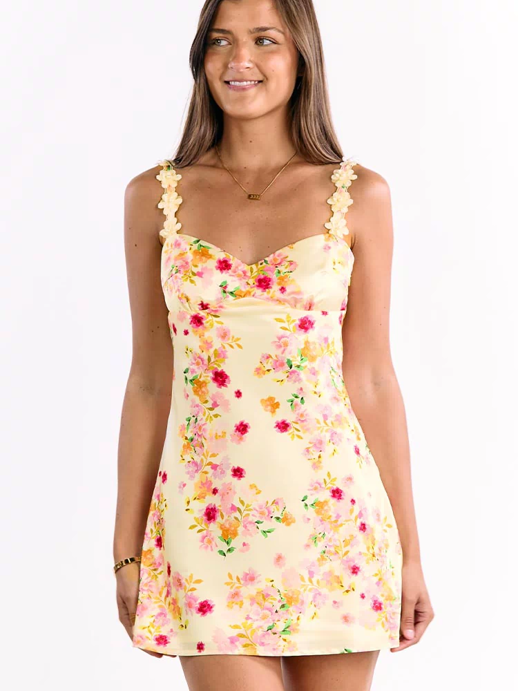 Yellow satin mini dress with a sweetheart neckline, pink and orange floral print, and floral-shaped shoulder straps