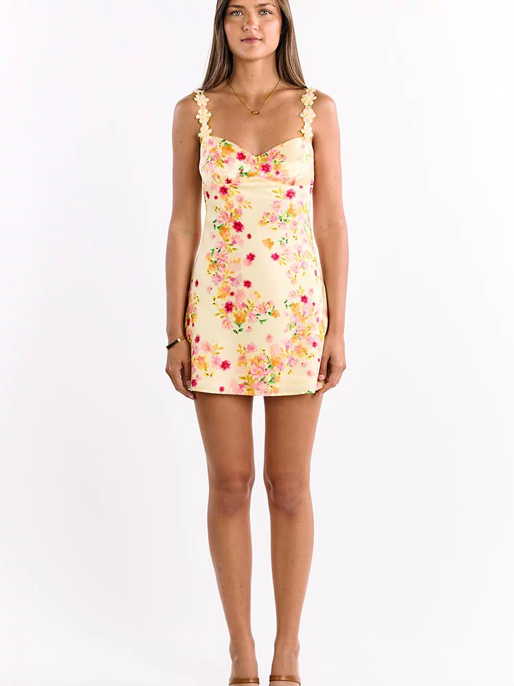 Full-length front view of a yellow satin mini dress with a vibrant pink floral print and 3D flower straps