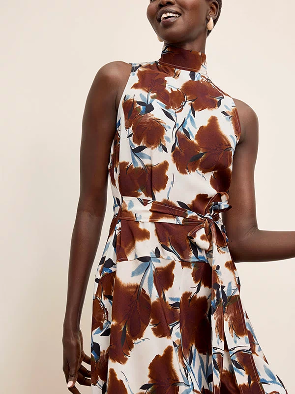 Woman wearing a sleeveless dress with a floral pattern on a beige background | Exclude | Grid Hover