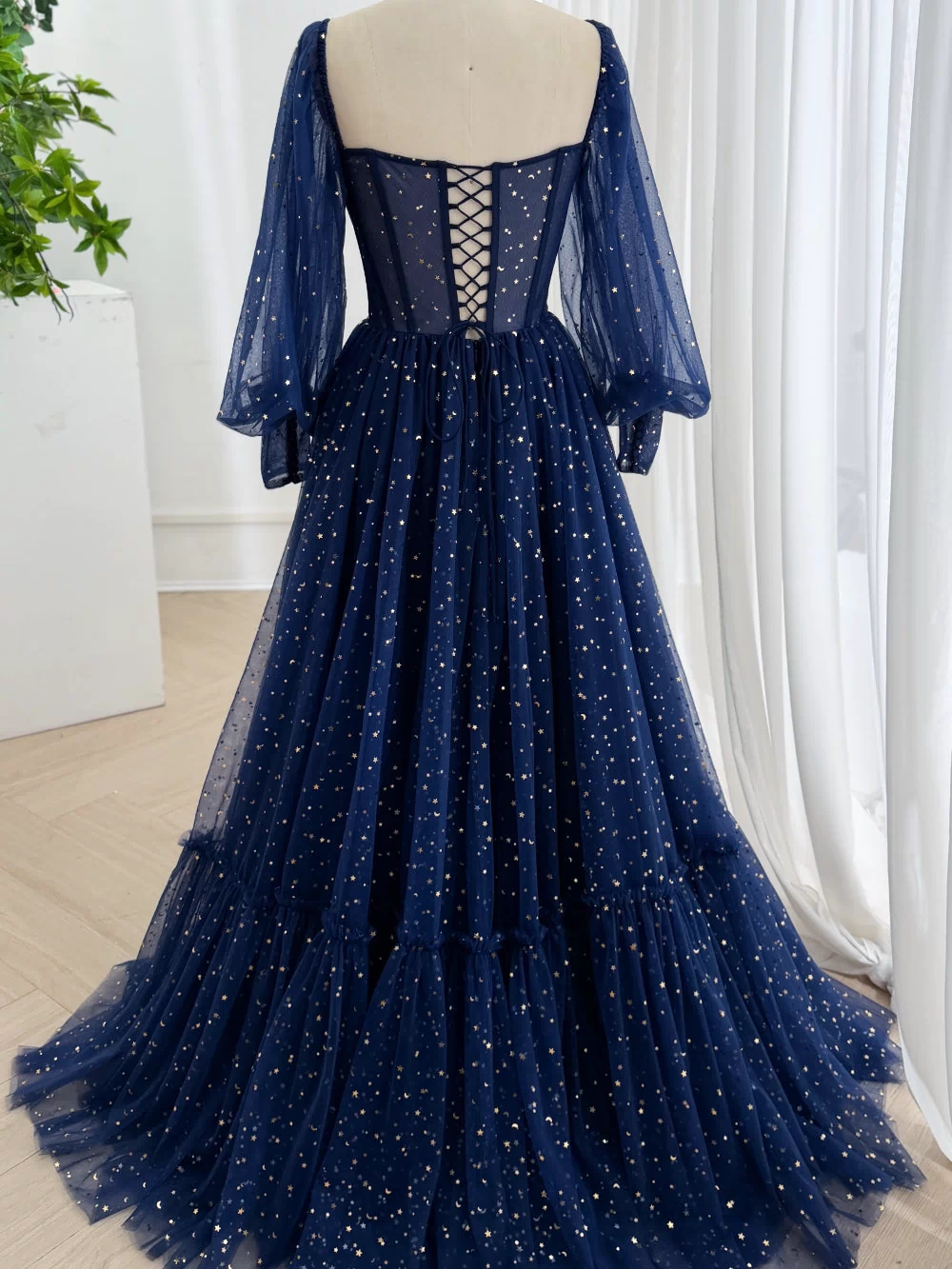 Studio shot highlights floor hem, gathered skirt volume, shimmering night-sky fabric, chapel silhouette, dramatic drape flow.