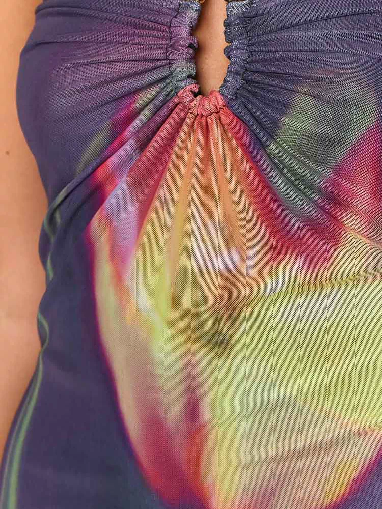 Detail of the ruched strapless neckline with a keyhole cutout and gold beads on a vibrant abstract mesh midi dress