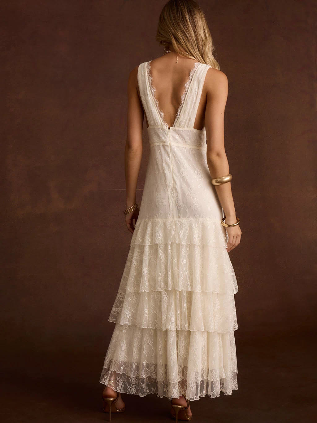 Back view of cream lace maxi dress with V-back and tiered ruffle skirt.