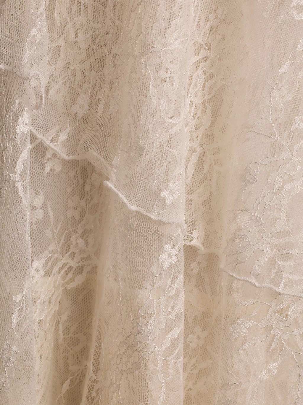 Close-up of cream floral lace fabric showing tiered layers on the Mon Amour maxi dress.