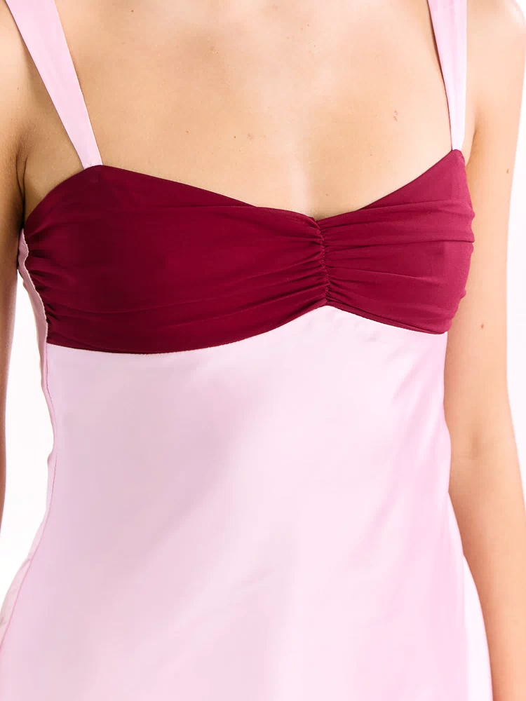 Close-up showing the ruched burgundy bust panel and light pink spaghetti straps of the pink contrast mini dress