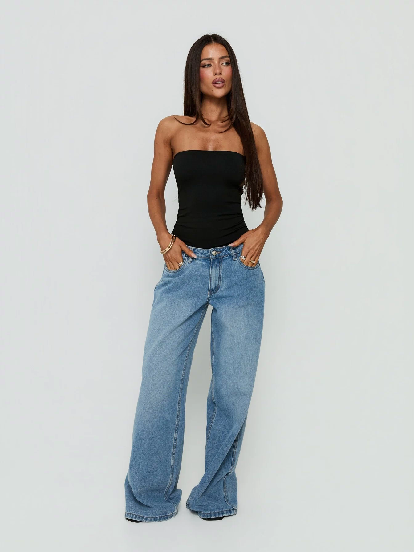 Showcasing the Namari Strapless Bodysuit Black womens-bodysuit with sleeveless and ruched details front view of model wearing Princess Polly