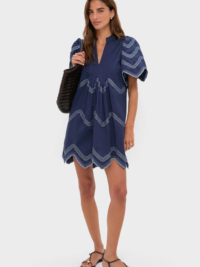 Navy Embroidered Weston Mini Dress: A classic, effortless style featuring puffed sleeves, scalloped embroidery, and pleats, perfect for fun, high-end, warm-weather occasions.