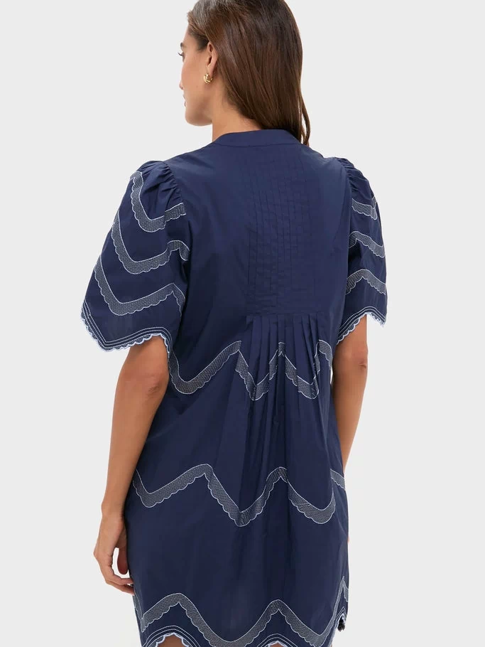 Navy Embroidered Weston Mini Dress with classic puffed sleeves, scalloped hem, and intricate detailing, embodying an effortless, fun, and high-end appeal. Perfect for versatile styling.