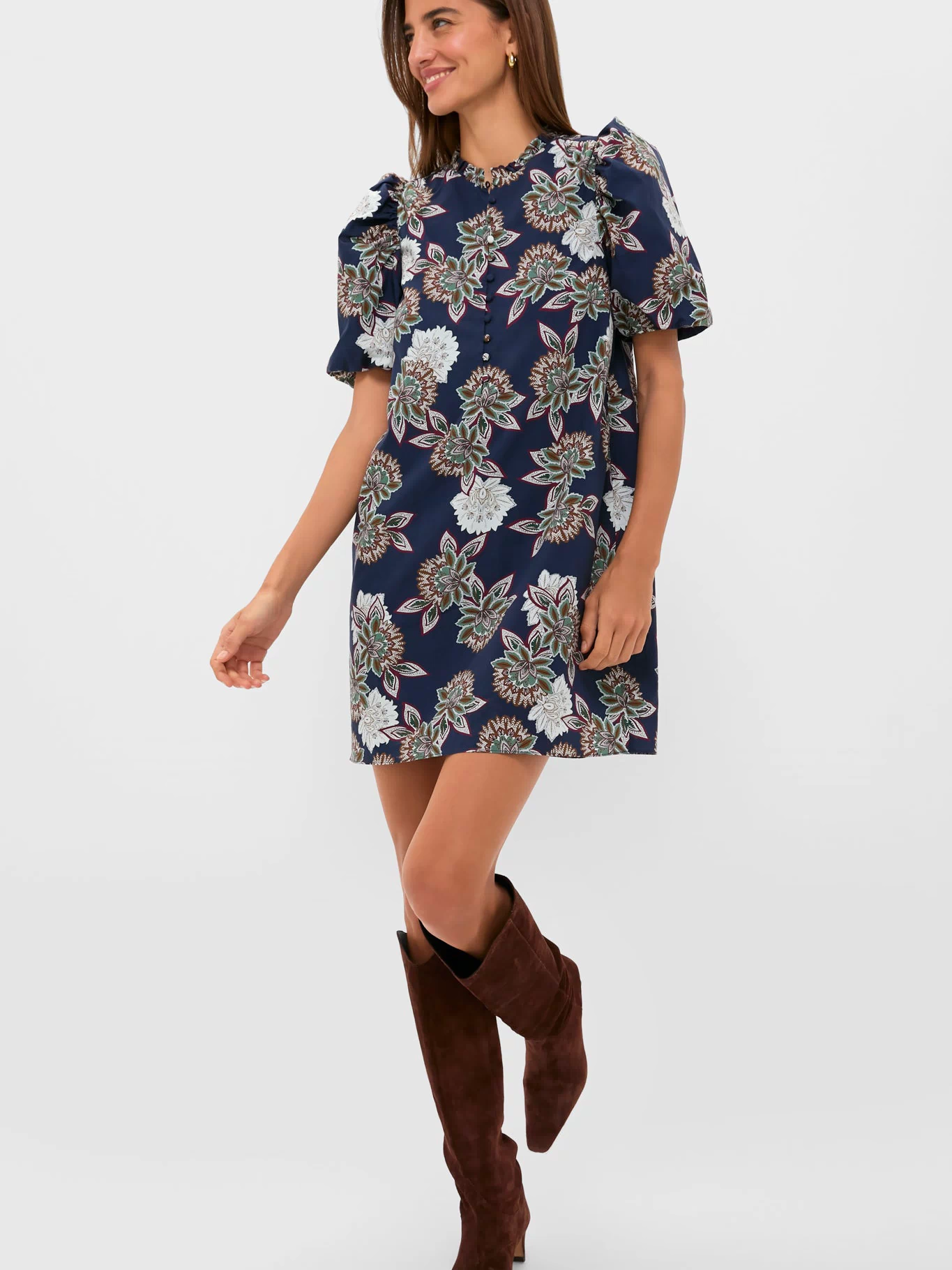 Young woman models the classic Navy Floral Mimi Mini Dress with puff sleeves, ruffle collar, and suede boots, embodying an effortless, high-end, and fun style.