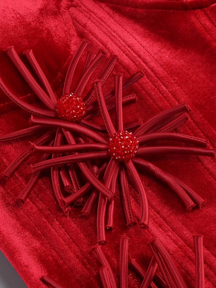 Close-up of a red textured fabric with decorative flower embellishments.