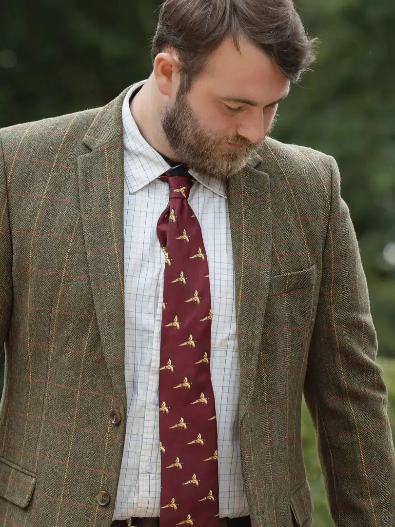 Man in forest heritage tweed blazer with white patterned shirt and burgundy pheasant tie