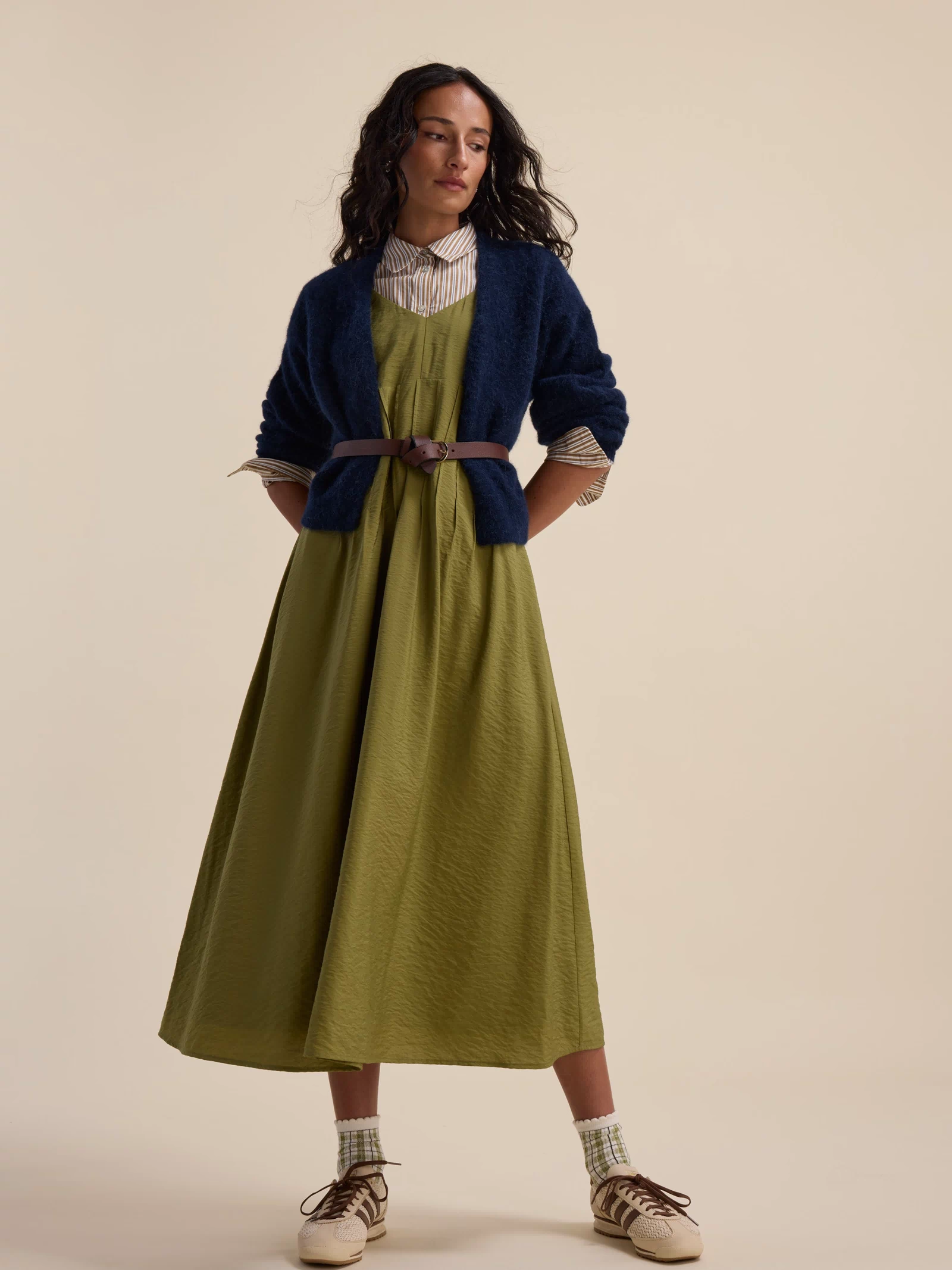 Woman in a Max Nina Fit and Flare Dress, blue cardigan, brown belt, and sneakers.
