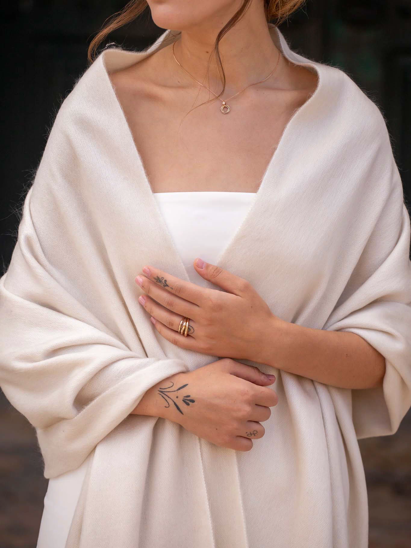 Pearl alpaca wedding shawl folded across bride's arm