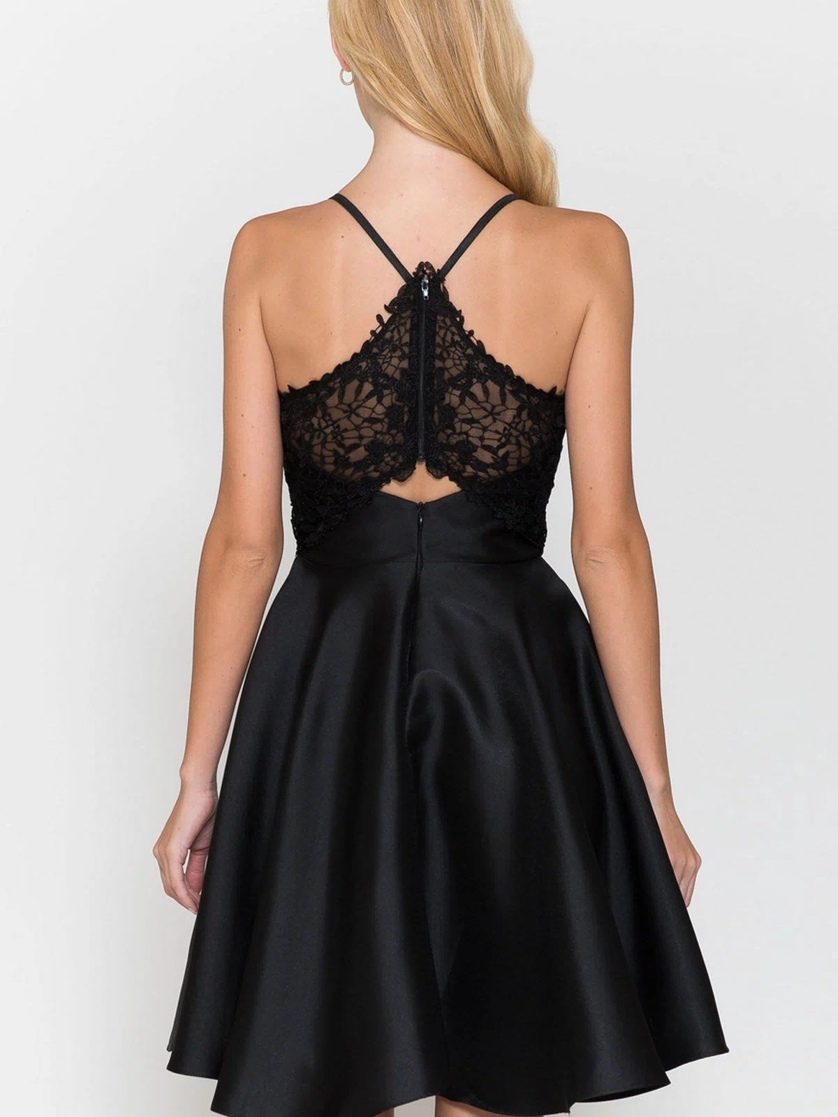 A woman faces away, wearing the Lace-Back Short A-Line Homecoming Dress 8698 featuring a sleeveless black design with lace detailing on the upper back and a flared satin skirt—an elegant choice for any party.