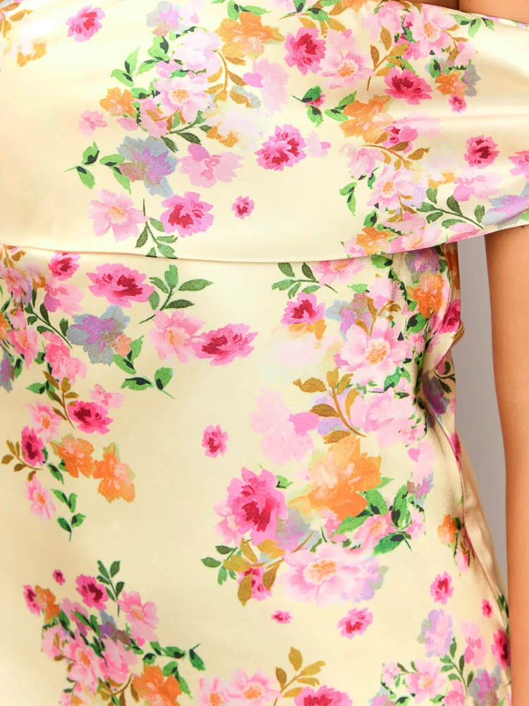 Close-up of the primrose yellow floral print fabric with pink, orange, and green flowers, showing the off-the-shoulder ruffle