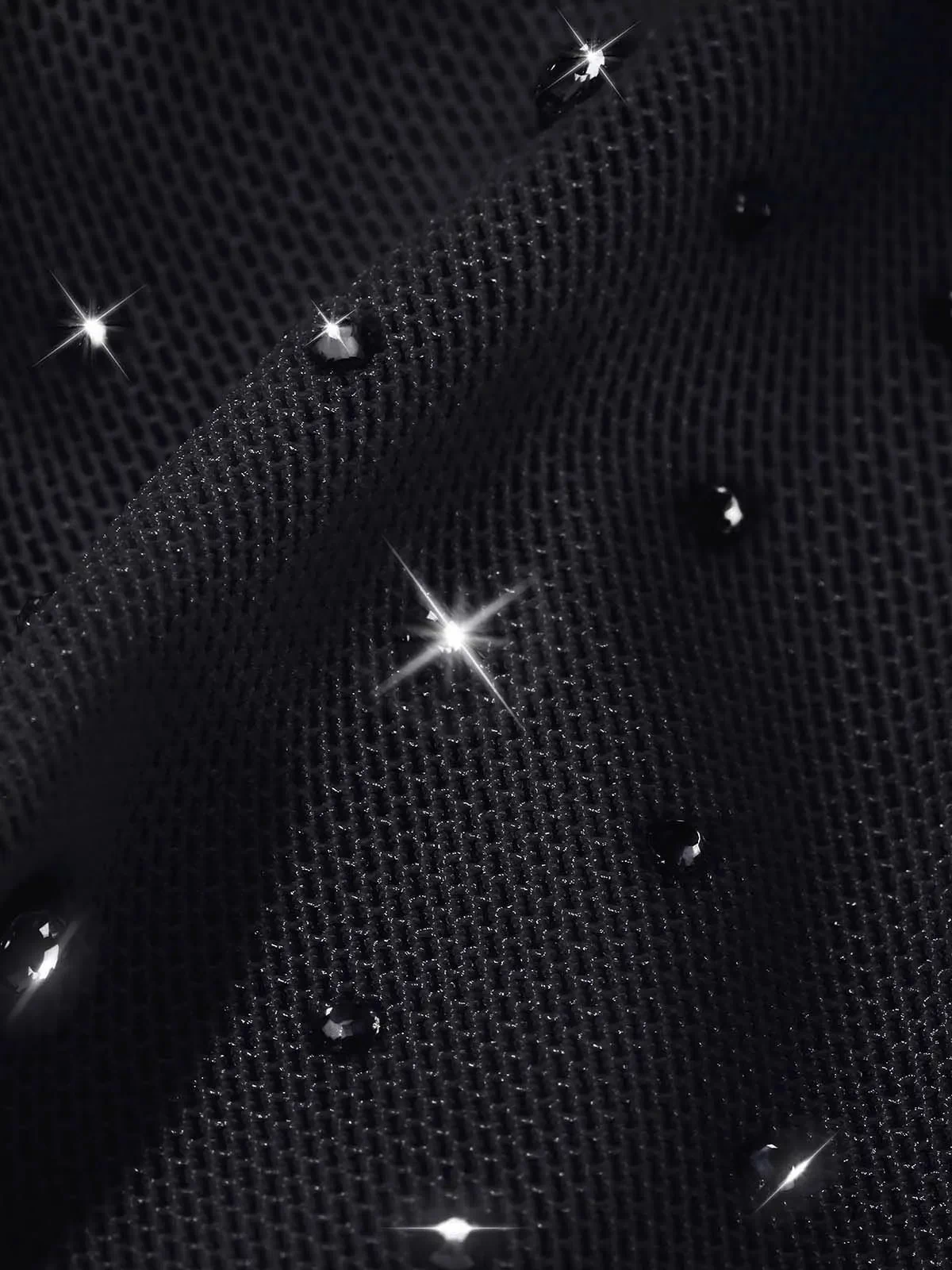 Close-up of Popilush® black mesh fabric with sparkling rhinestones for a glamorous effect.