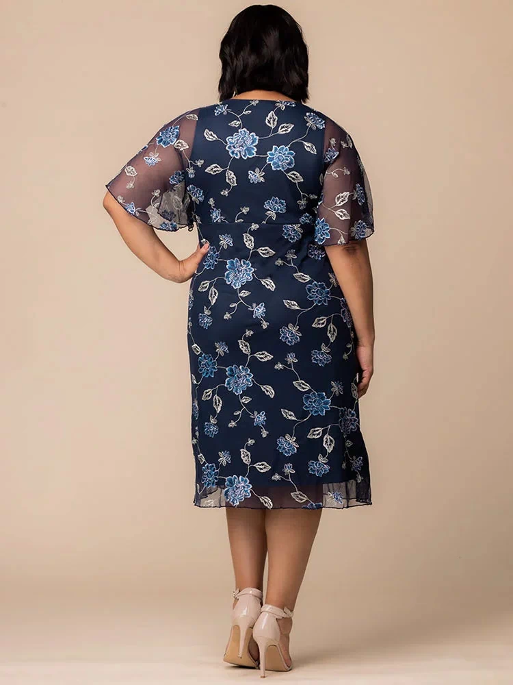Sonnet Embroidered Midi Cocktail Dress in Navy Blue Blooms  Back view of plus size model in navy blue embroidered mesh midi dress with sheer flutter sleeves, showing full coverage and flowy hem for special occasion wear.
