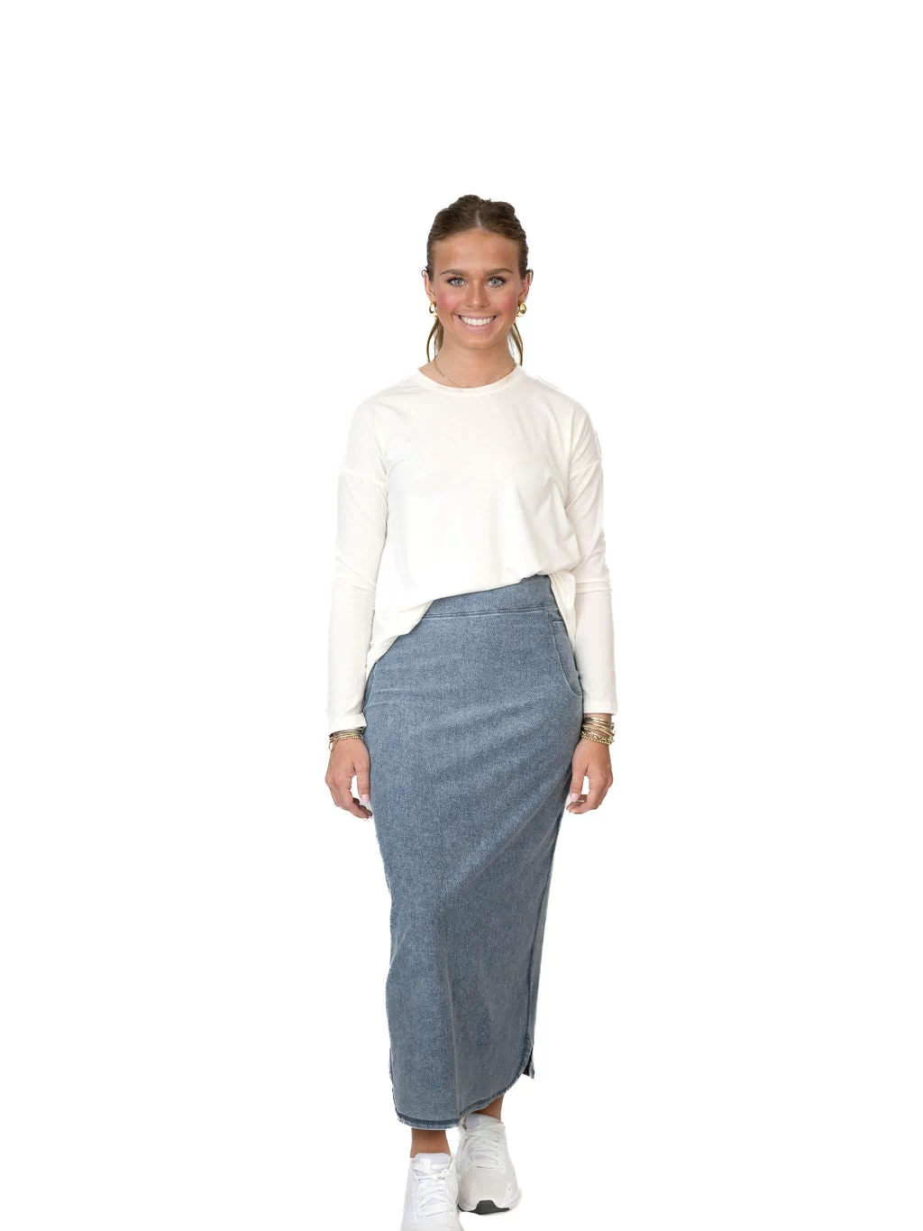 Woman modeling Snoga Athletics modest denim skirt with white long-sleeve top and sneakers