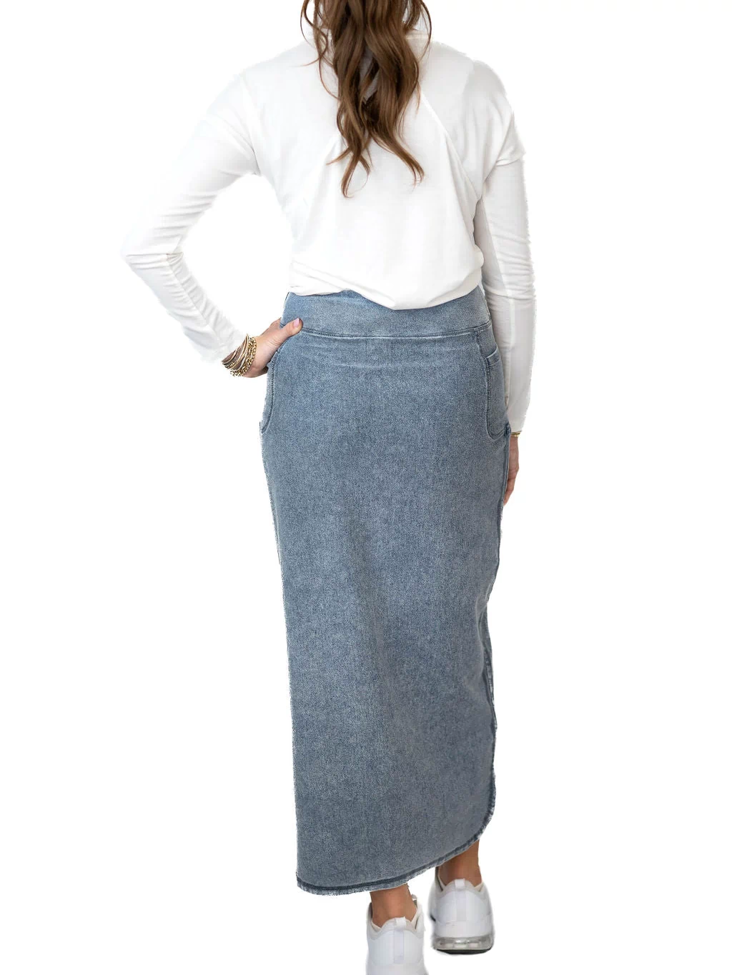Snoga Athletics woman wearing a modest denim maxi skirt and white top, viewed from back