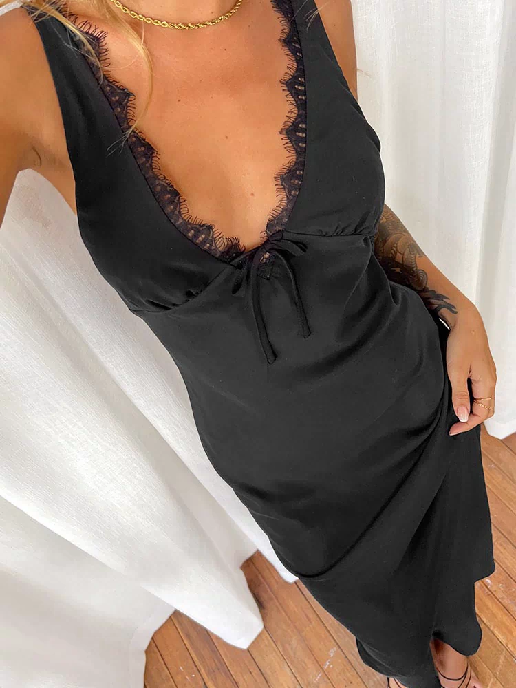 Close-up of the black maxi dress showing the V-neckline with delicate lace trim and a tie detail at the bust