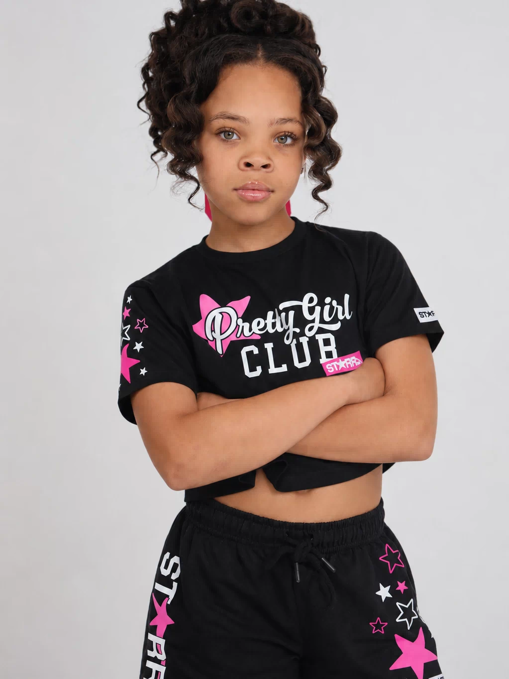 Black and pink Starr Girls Pretty Girl Club short sleeve crop top shown on a girl, casual style with vibrant color details.