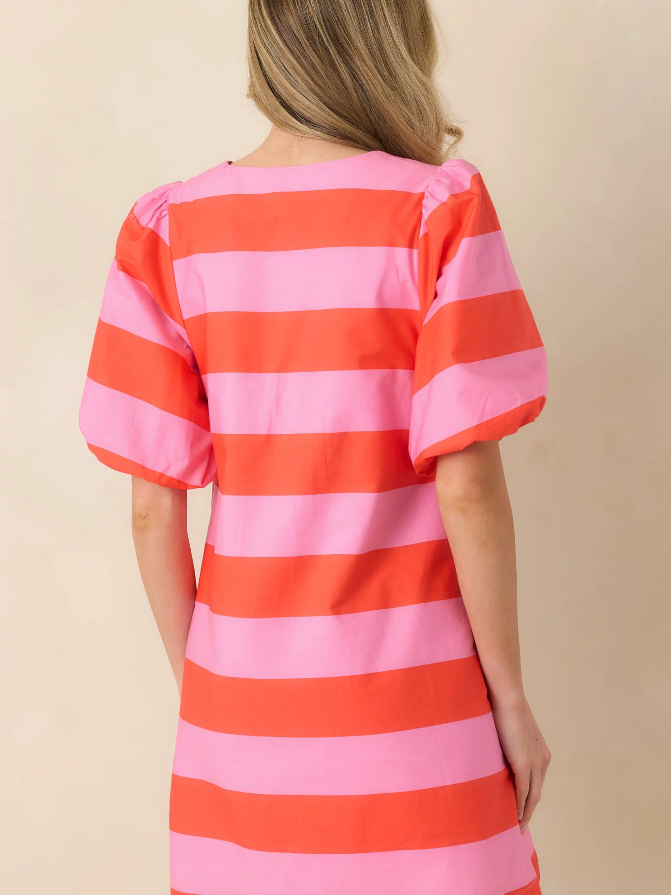 Rear view of the striped mini dress featuring the continuous bold stripe pattern and flattering shape