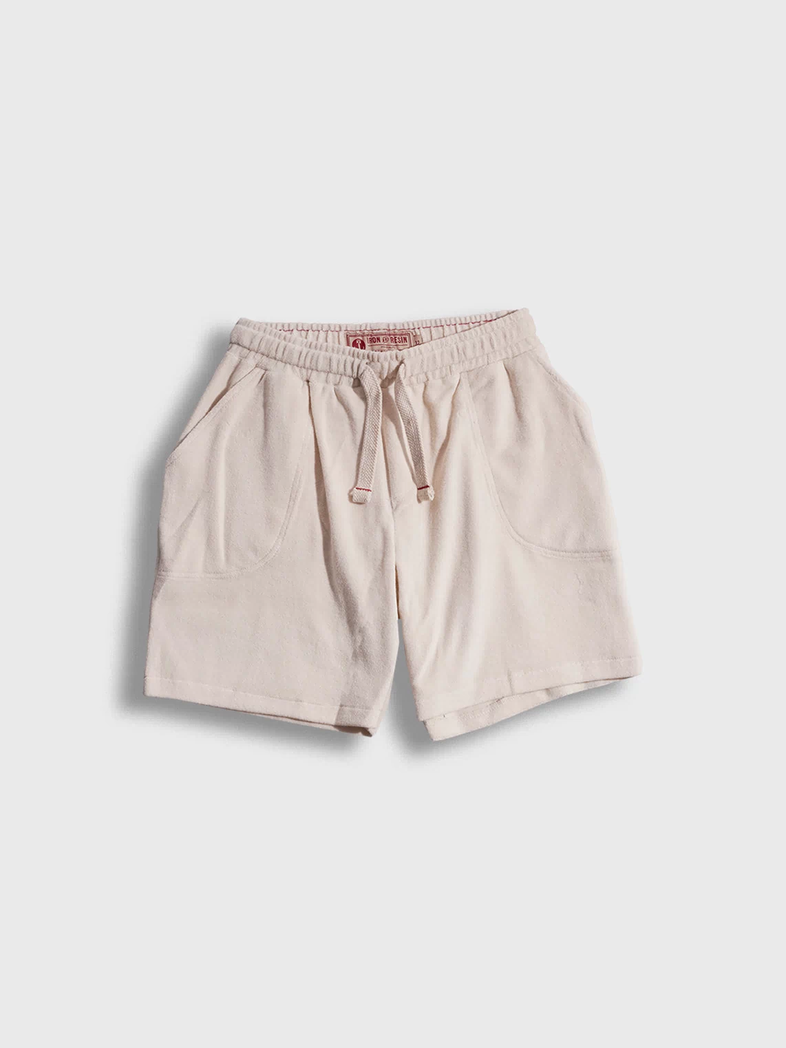 Beige drawstring shorts with front pockets, displayed on a white background, showcasing casual style and comfort.