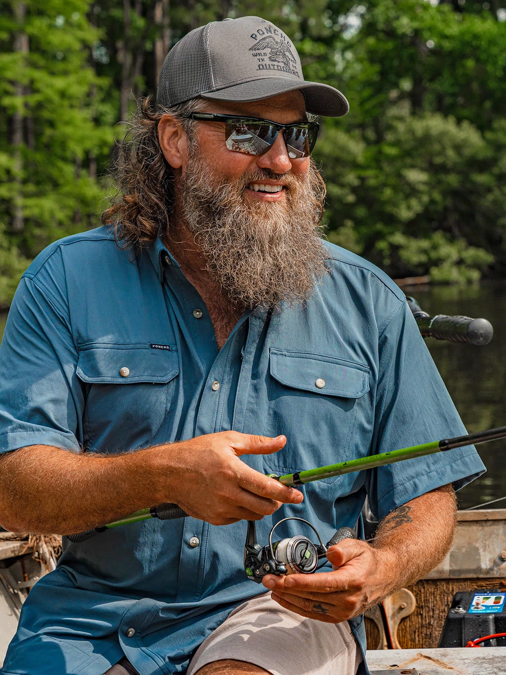 Man fishing on a boat wearing The Ahi breathable outdoor shirt and sunglasses