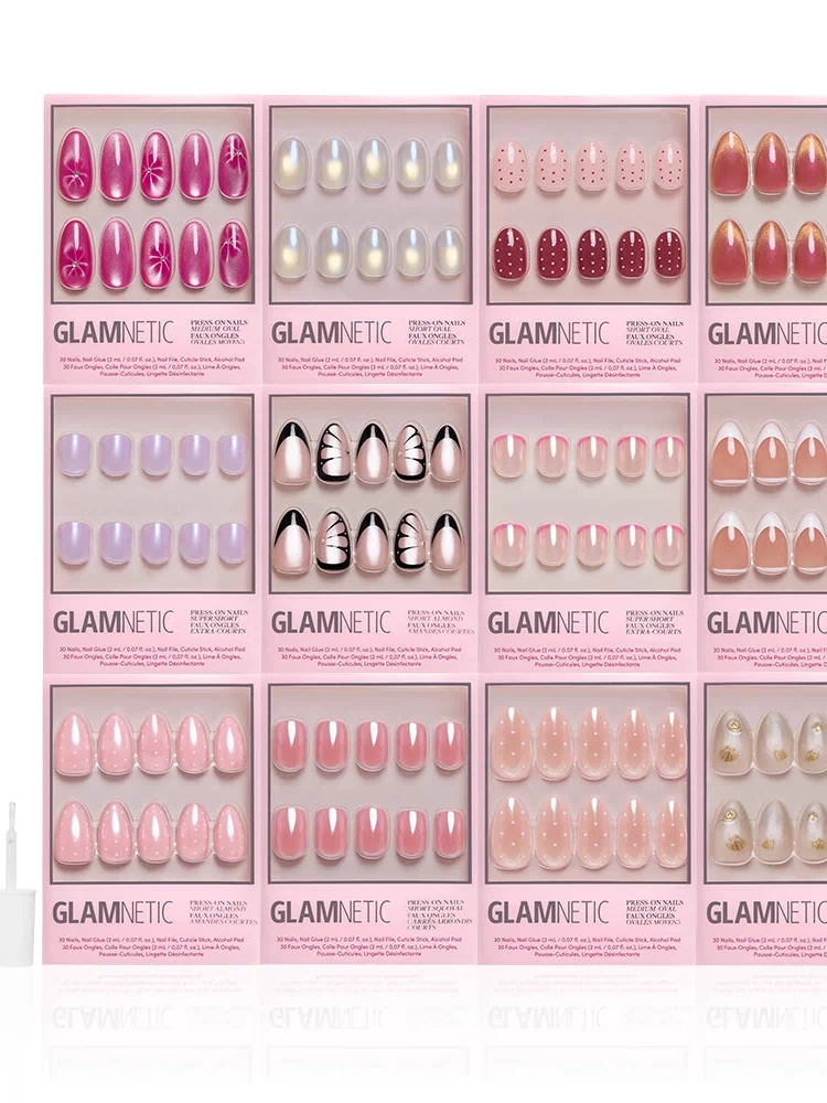 The Spring Edit Collection by glamnetic features twelve spring nail sets in assorted colors and shimmery designs, arranged in a grid with a pink bottle and applicator on the left. Each box highlights unique luminous nails, patterns, and shades.