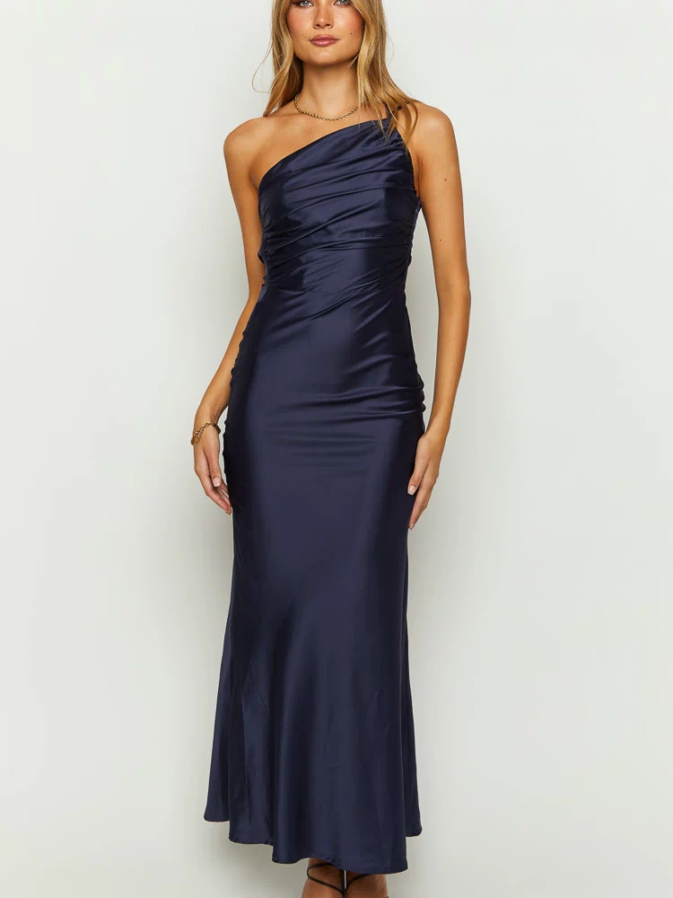 Front view of a navy one-shoulder maxi dress with a draped and ruched bodice and a smooth flowing maxi skirt