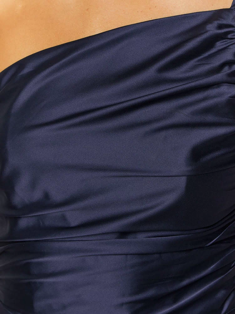 Close-up of the navy satin one-shoulder neckline and ruched bodice of a formal maxi dress