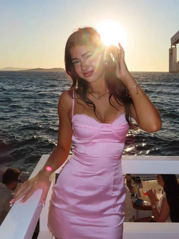 Light pink satin mini dress with a bustier bodice and delicate lace trim on the cups