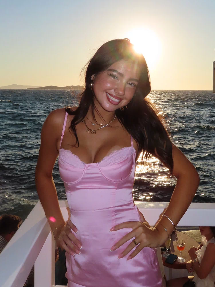 Front view of a light pink satin bodycon mini dress with a lace-trimmed sweetheart neckline and thin spaghetti straps