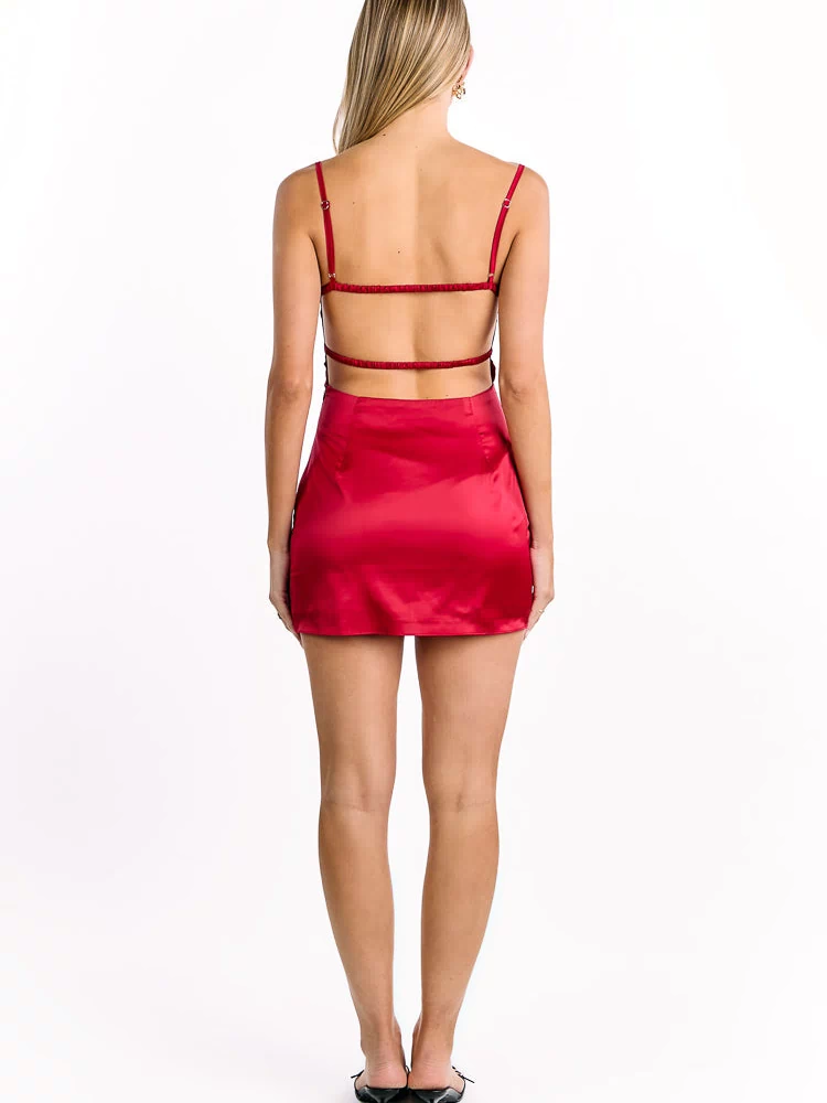 Back view of a wine red satin mini dress with thin adjustable spaghetti straps and two horizontal elasticated back straps