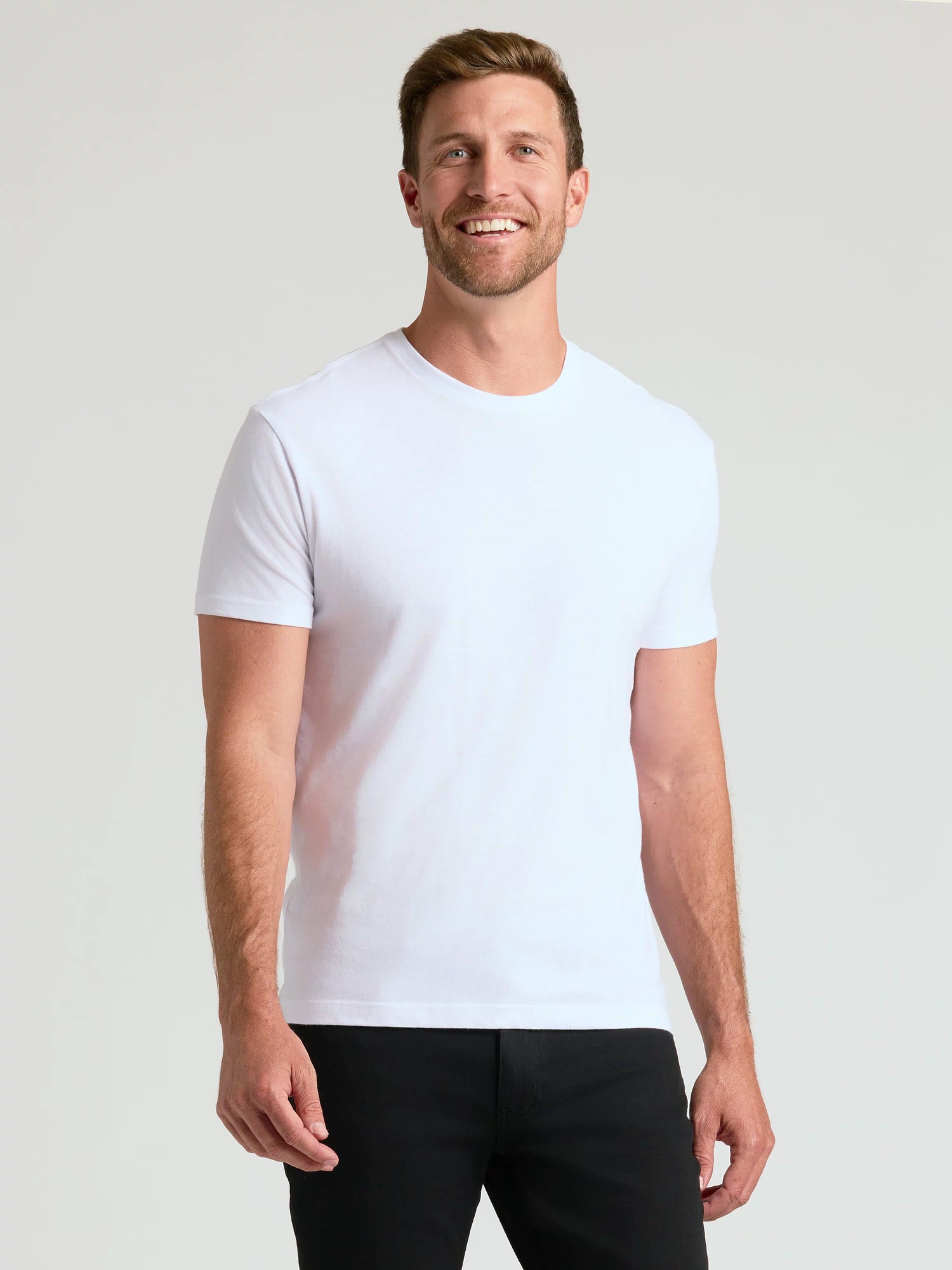 Man in Black and White Crew Neck 10-Pack, smiling in casual attire.