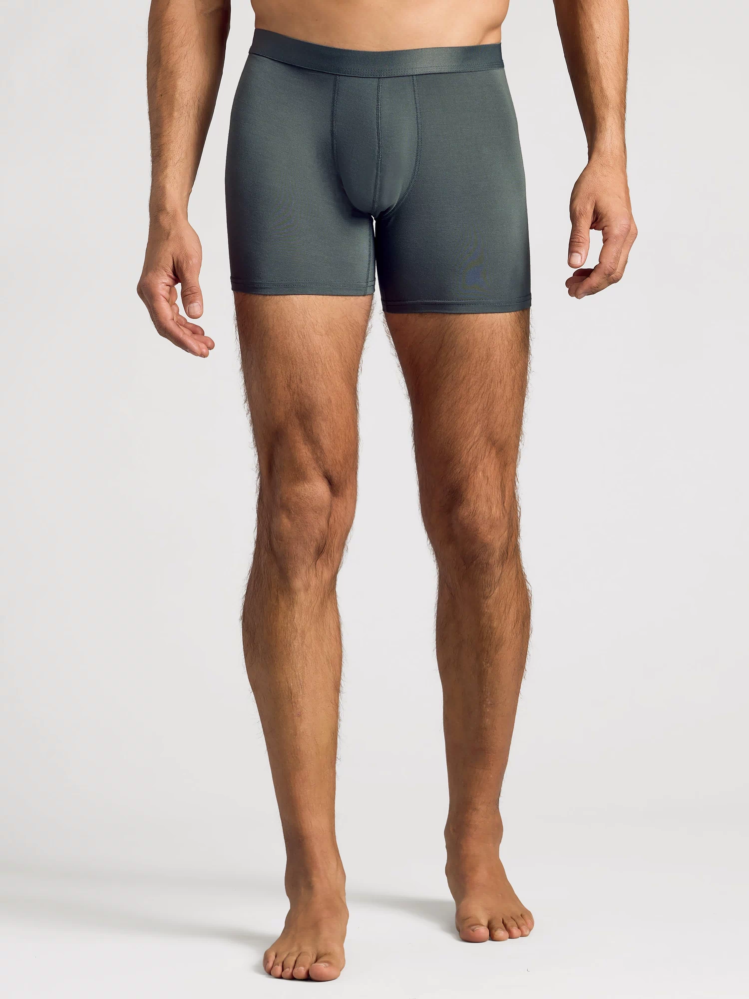 Man wearing Carbon Boxer Brief, showcasing snug fit and mid-thigh length.