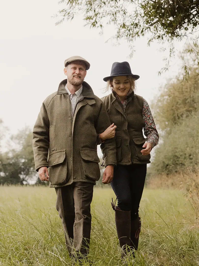 English made tweed jacket in olive green waxed canvas with flat cap and boots