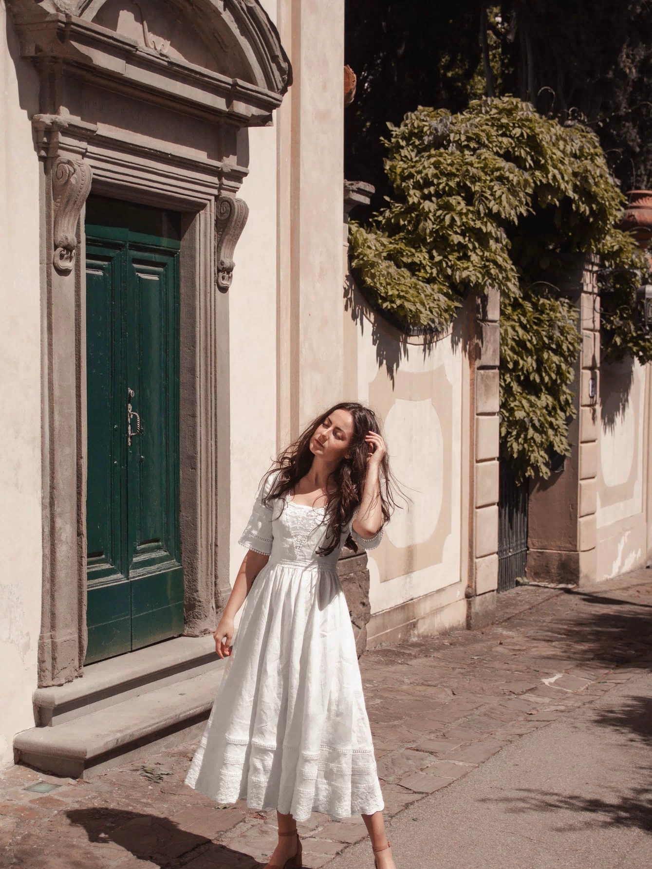 Under the Tuscan Sky ivory linen wedding dress photographed on a historic Italian village street