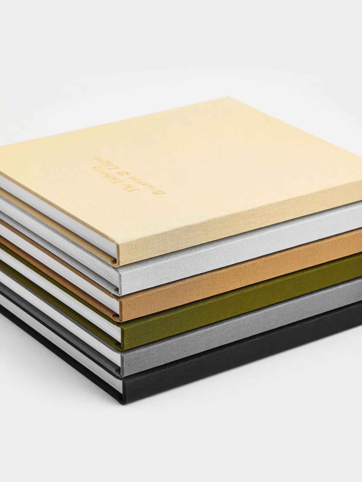 Stack of wedding photo albums with different colored covers on a white background