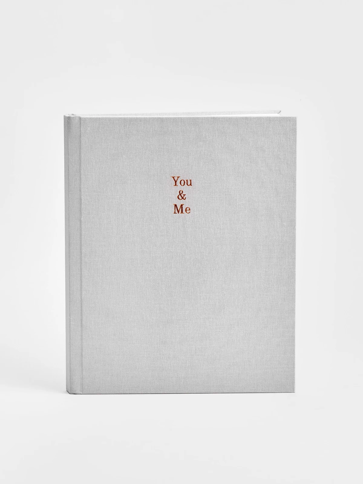 Gray linen photo album with 'You & Me' gold foil on a white background