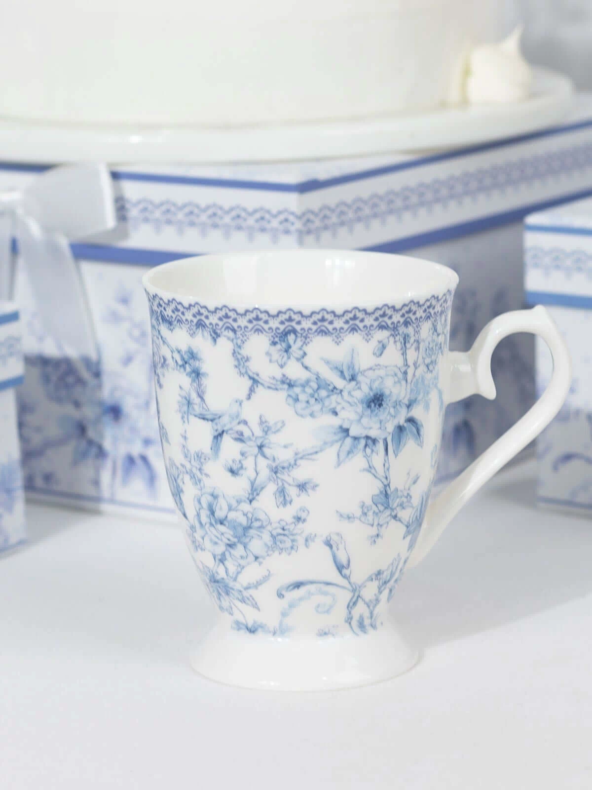 Decorative blue and white floral porcelain cup on a plain background.