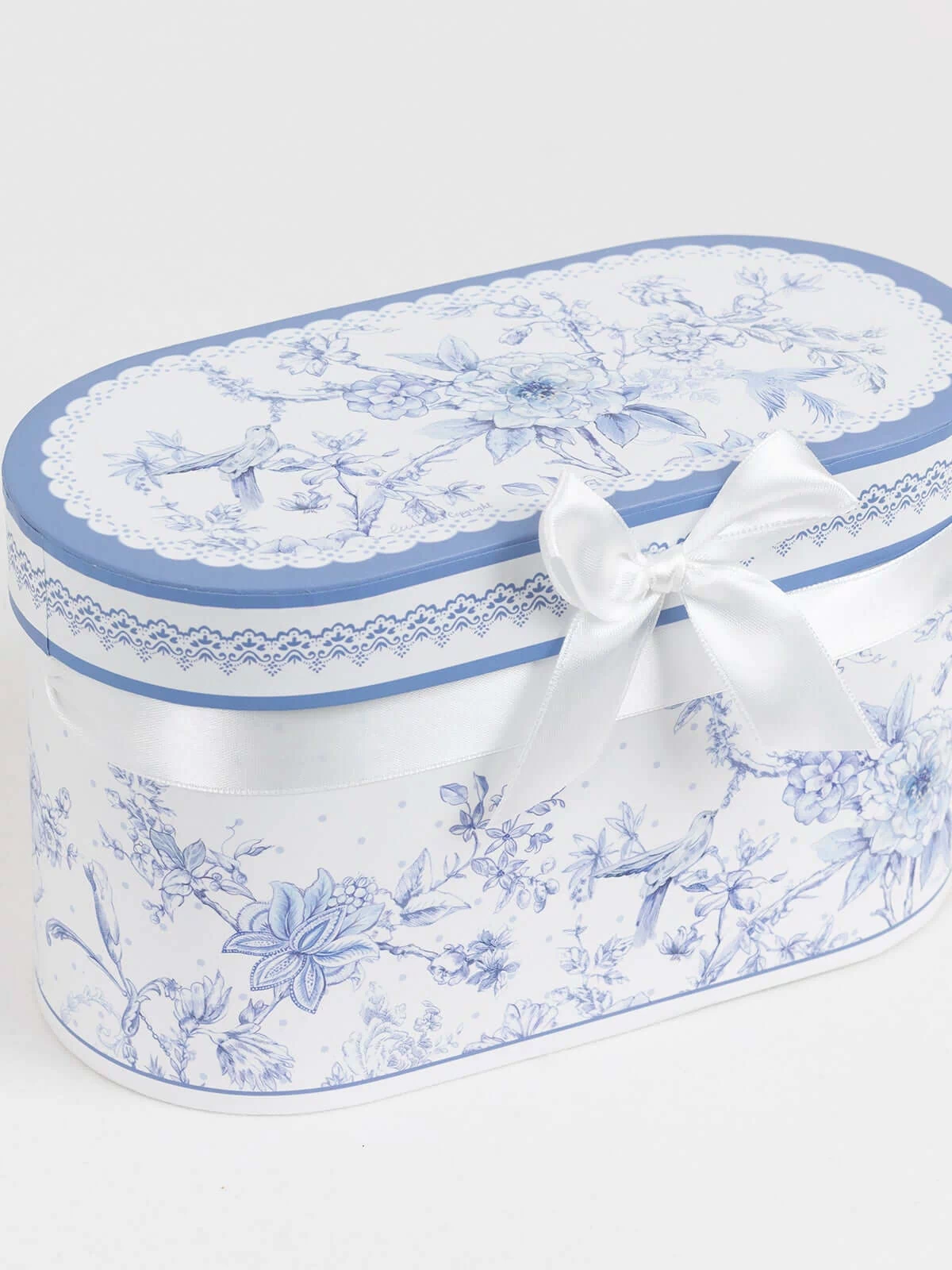 Blue floral printed gift box with a white ribbon bow