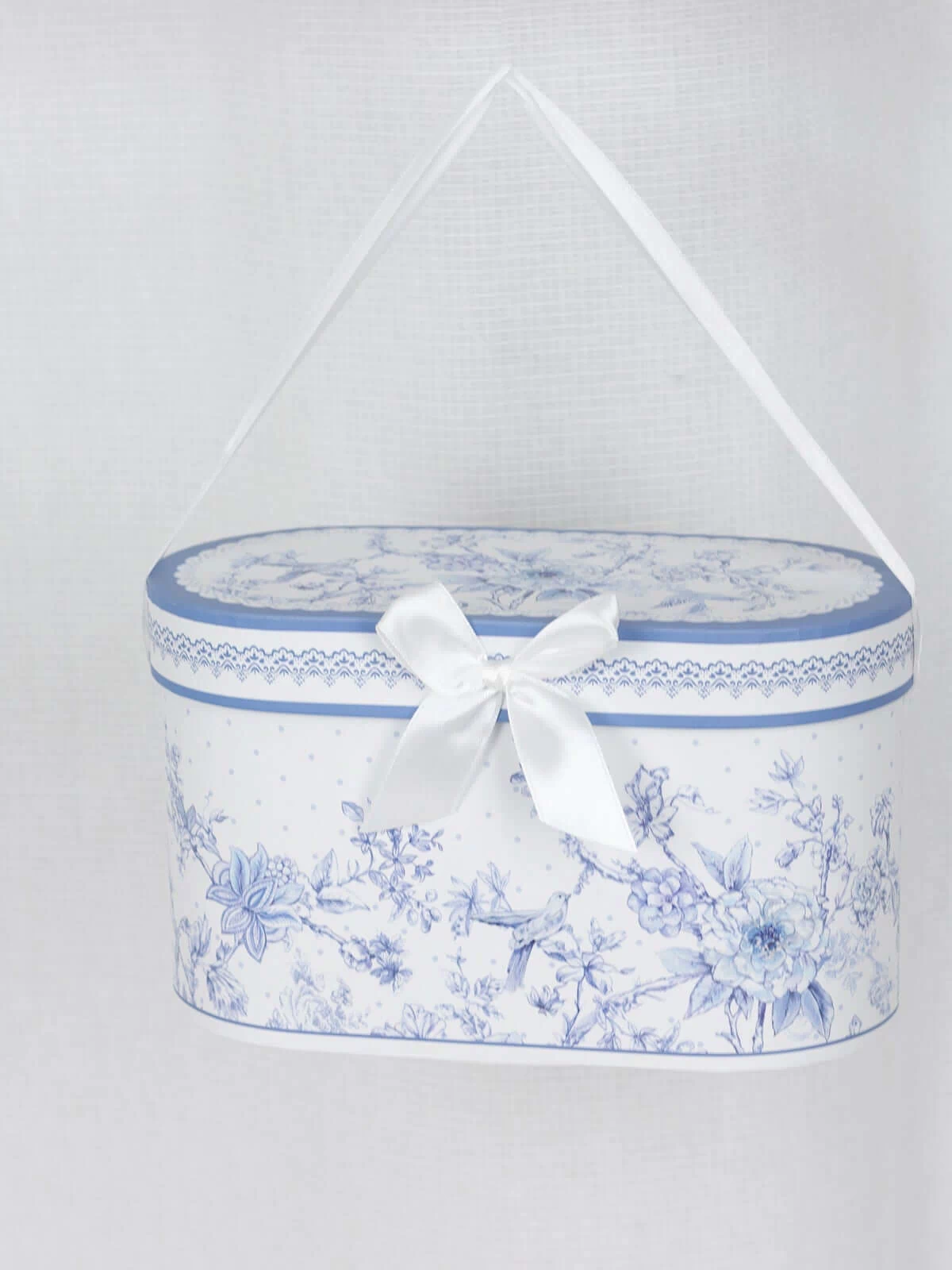 Decorative blue and white floral storage box with a ribbon handle