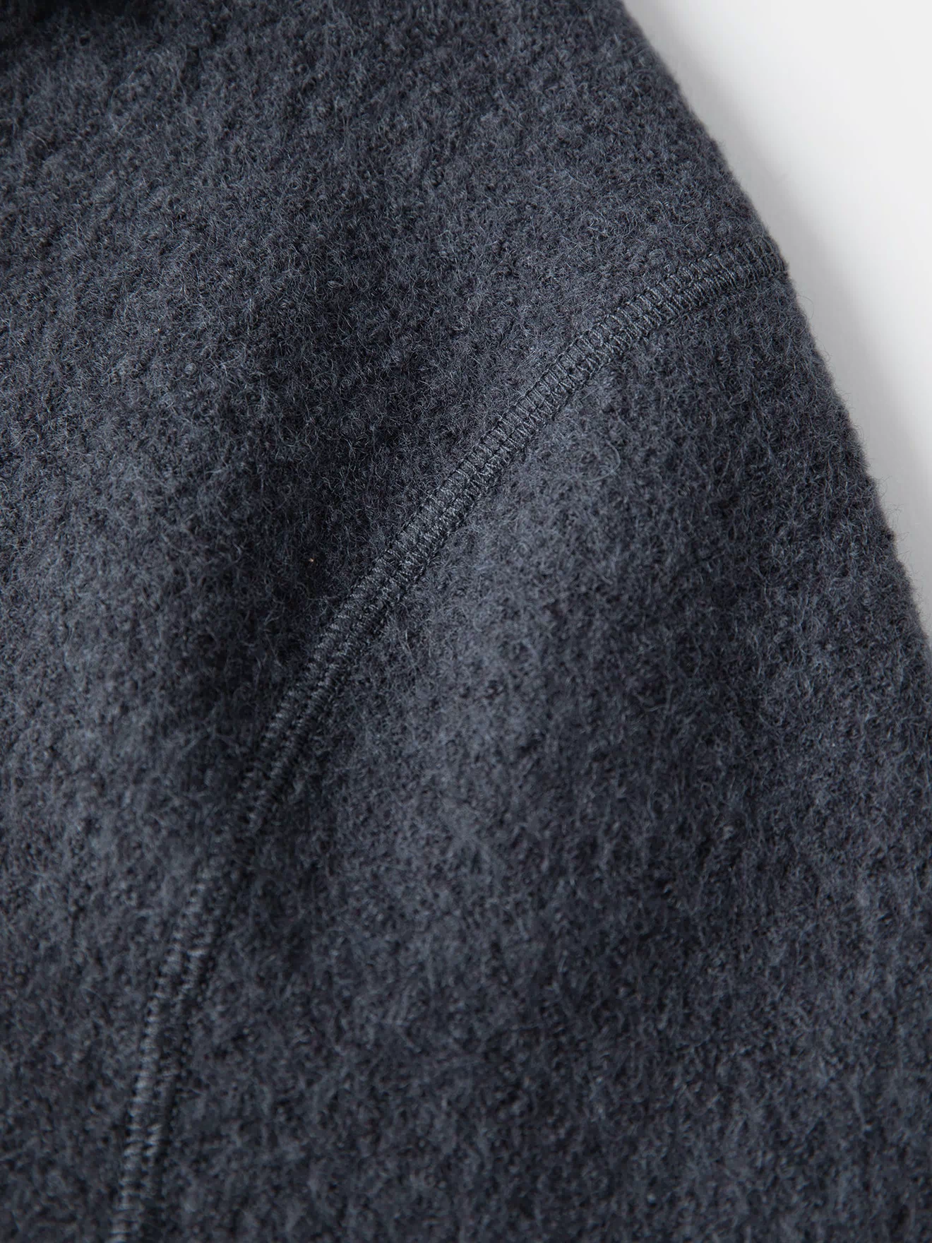 Gray wool felted chore coat fabric texture with stitched seam line detail