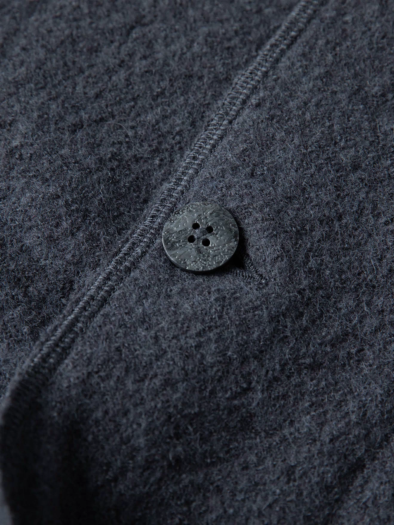 Gray wool felted chore coat front button close-up with buttonhole stitching