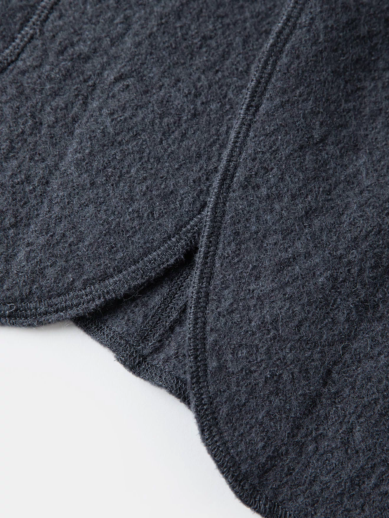 Gray wool felted chore coat hem corner with stitched construction detail